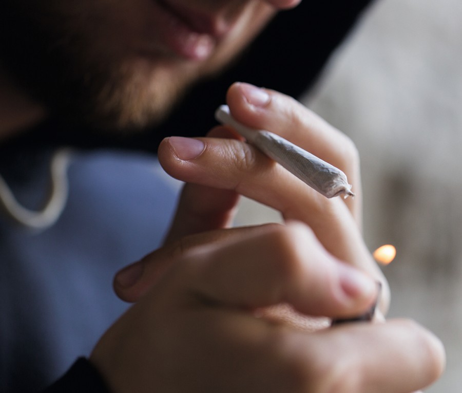 Ein Mann zündet sich einen Joint an. cannabis_rauchen_115882569_f_syda_productions.jpg