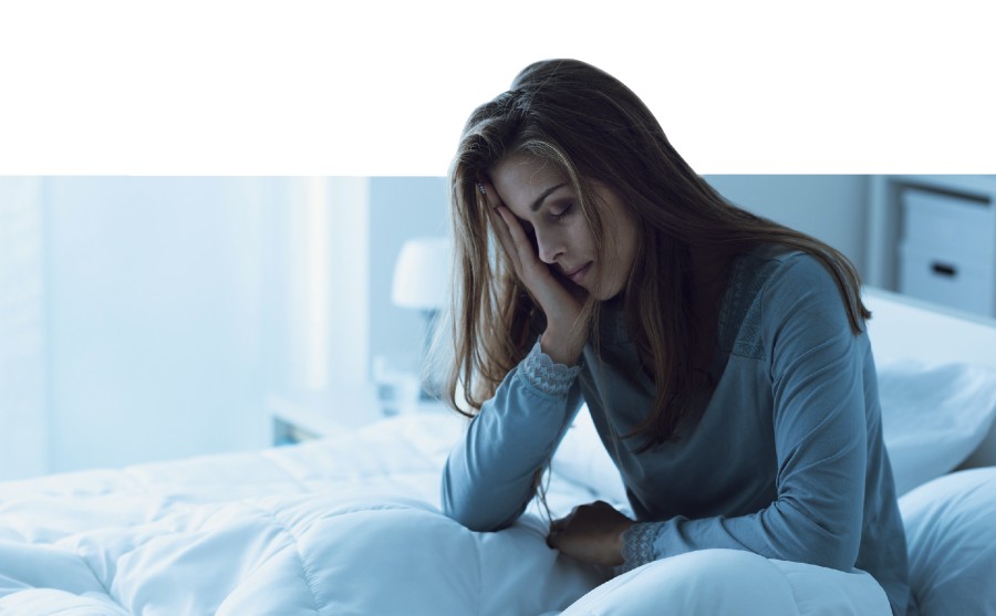 Im Bett sitzende Frau, die sich den Kopf hält und müde und abgeschlagen wirkt cme_henneberg_fatique_f_243638688_f_stockphotopro.jpg